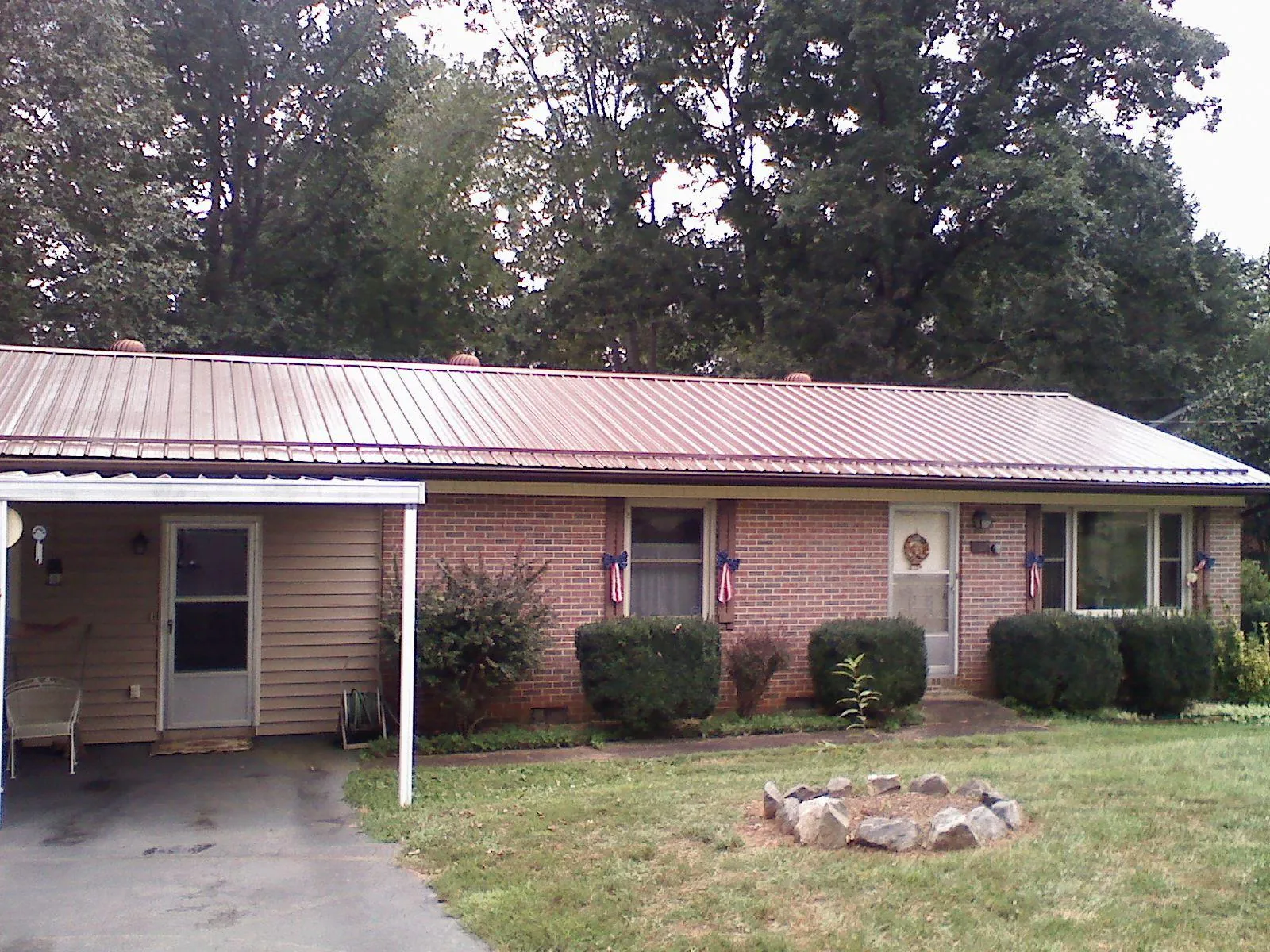Bronze metal roof and carport on a brick ranch home — Roof Repair work by our crew in Silver Point